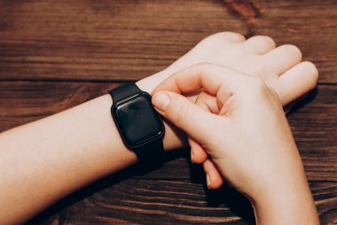 Elinde siyah teknolojik akıllı saat.