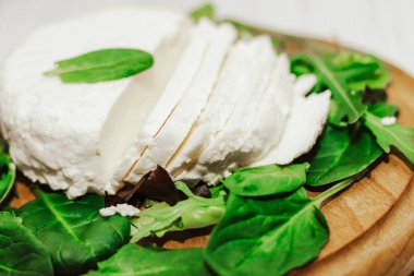 Sülüguni ahşap bir tahtanın üzerinde otlarla peynir turşusu kurdu..