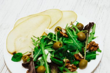 Armutlu salata, otlar, roka, prosciutto, peynir, yeşil zeytin ve fındık..