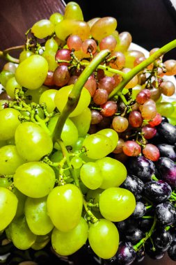 Dalların üzerinde mor ve yeşil üzümler..