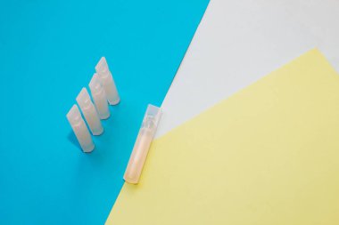 Mavi arka planda küçük şişedeki probiyotik ilaçları.