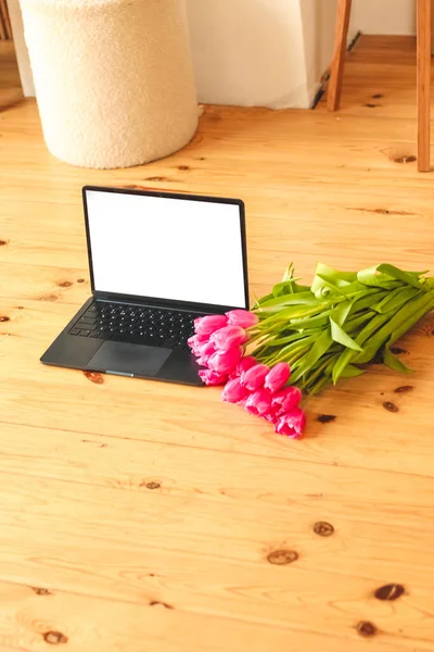 컴퓨터가 널빤지 배경에 분홍색 꽃다발을 이루고 — 스톡 사진