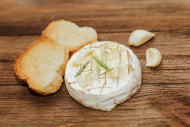 Masada zeytinyağı ve peynirli ekmek dilimleri var..