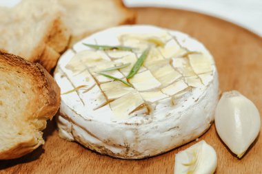 Masada zeytinyağı ve peynirli ekmek dilimleri var..