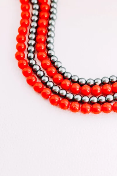 一条白色美学背景的红色和灰色珠子项链 — 图库照片