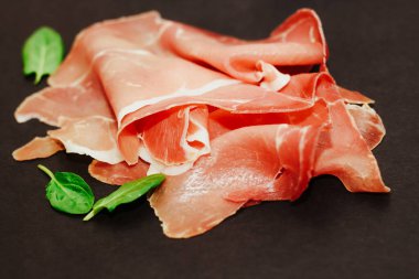 Kara tahtada kurutulmuş domuz jambonu jambonu parçaları..