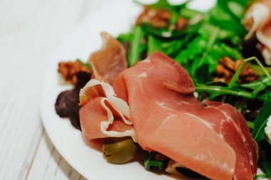 Otlu salata, roka, jambon, peynir, yeşil zeytin ve fındık..