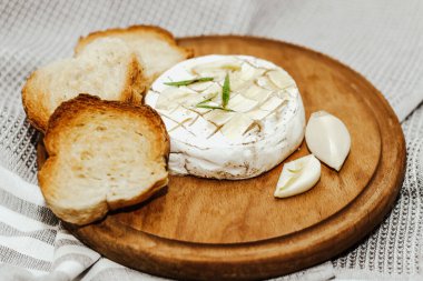 Masada zeytinyağı ve peynirli ekmek dilimleri var..