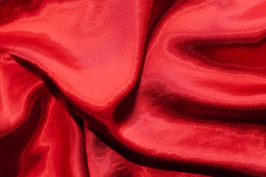 Kıvrımlı ipek satenin kırmızı parlak dokusu.