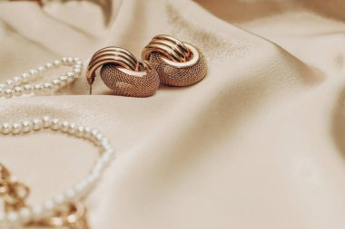 Kadın mücevherleri, altın zincir, ipek arka planda moda mücevherler..