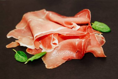 Kara tahtada kurutulmuş domuz jambonu jambonu parçaları..