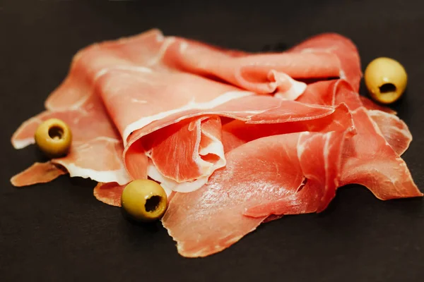 Pedaços Porco Seco Jamon Prosciutto Com Azeitonas Uma Placa Preta — Fotografia de Stock
