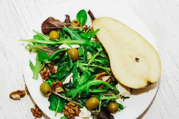 Armutlu salata, otlar, roka, prosciutto, peynir, yeşil zeytin ve fındık..