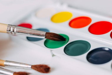 Suluboya çok renkli boyalar çizim için fırçalarla yakın plan.