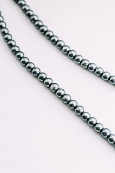 一条白色美学背景的灰色珠子项链 — 图库照片