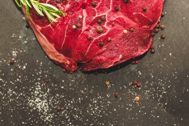 Taze et. Kemik ossobuco 'sunda büyük biftek. Siyah arka planda biber var..