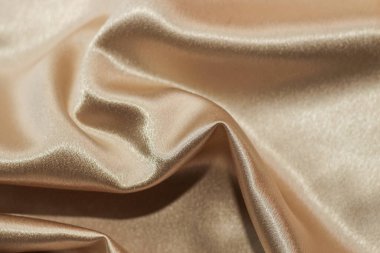 Katlı ipek saten kumaşın altın gibi parlak dokusu..