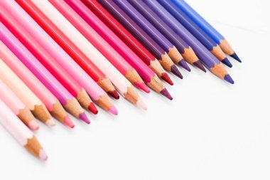 Çok renkli kalemler beyaz bir masanın üzerinde, menekşe renk aralığı..