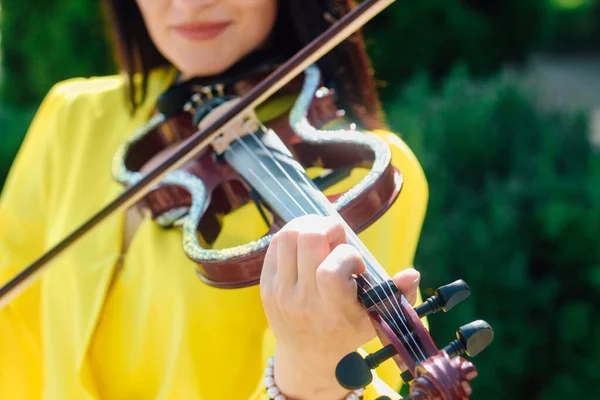 ドレスの暗い髪の女性アーティストは 木製のコンサート電動バイオリンを果たしています — ストック写真