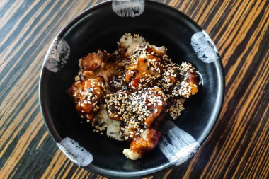 Teriyaki soslu tavuk, pilav ve susam tohumu.