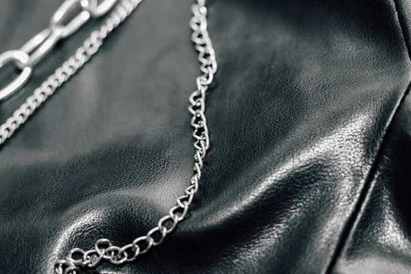 Chain on black texture eco soft leather, fashionable jacket.