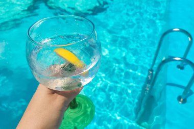 Mavi bilardo arka planında limon toniği olan kokteyl.