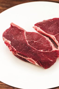 Bir parça kaliteli et, ahşap bir masada çizgili biftek.