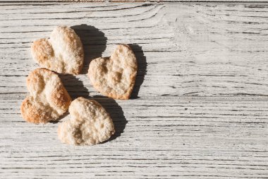 Kalp şeklinde ev yapımı kurabiyeler üzerine şeker serpilmiş.