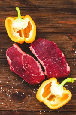 Bir parça kaliteli et, ahşap bir masada biberli çizgili biftek.