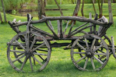 Yeşil bir bahçenin arka planında gri Tahta At Arabası