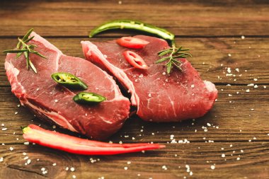 Bir parça kaliteli et, ahşap bir masada biberli çizgili biftek.