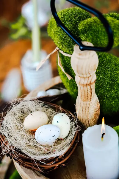 Bahar dekorasyonları renkli yumurtalar ve mumlarla dolu küçük bir yuva içeriyor, doğal bir açık havada sıcak bir atmosfer yaratıyor..