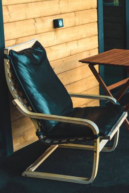 Sıcak güneş ışınları ve sükunetin tadını çıkarmak için mükemmel bir konumda, rahat, siyah bir şezlong oturmaktadır..