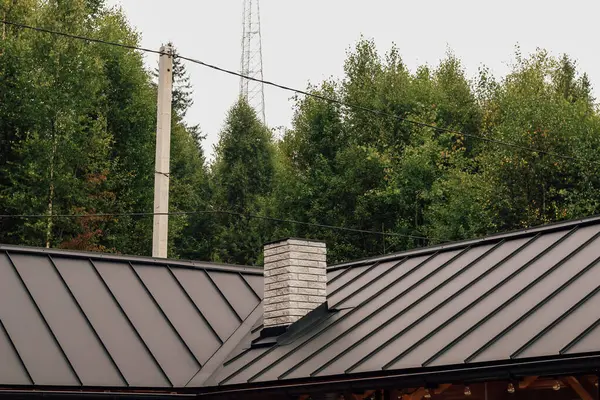 Canlı bir ormana yerleşmiş bu eşsiz yapı parlak bir çatıya ve yüksek ağaçlarla çevrili taş bir bacaya sahiptir..