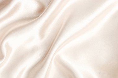 Lüks saten kumaş yumuşak ve zarif bir hareketle ışığı yansıtan yüzeyde pürüzsüz bir şekilde akıyor..