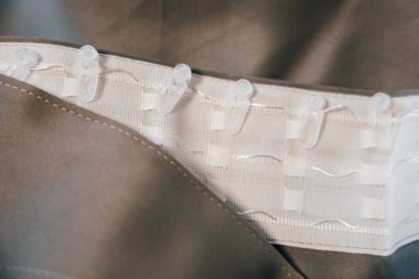 Yakın çekim görüntü, yumuşak bir kumaşa bağlanmış kanca ve döngüleri gösterir ve kıyafet tasarımında kullanılan bağlama mekanizmasını gösterir.