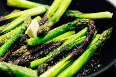 Taze kuşkonmaz mızrakları kızartma tavasında pişiriliyor ve üzerine tereyağı eritiliyor..