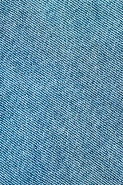 Giysi ve tekstil uygulamaları için çeşitli mavi renk tonlarına sahip ayrıntılı bir dokuyu gösteren kot kumaşın yakın görüntüsü.