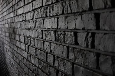Koyu renkli tuğla bir duvara yakından bakınca kaba dokusu ve benzersiz desenleri ortaya çıkıyor. Bu da kentsel ortamlarda tipik bir endüstriyel hissi uyandırıyor..