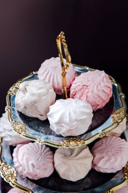 Katmanlı tezgah vitrinleri pembe ve beyaz kremalı pastalardan oluşan bir grup misafirleri toplanma sırasında tatlı bir ziyafetin tadını çıkarmaya davet ediyor..