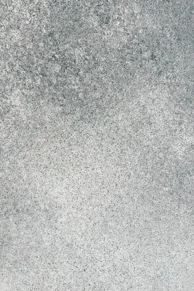 Gri bir yüzeyin yakın plan görüntüsü ince dokuları ve doğal ışık altında ton çeşitliliklerini gösteriyor. İnce desenler görsel ilgi yaratıyor..
