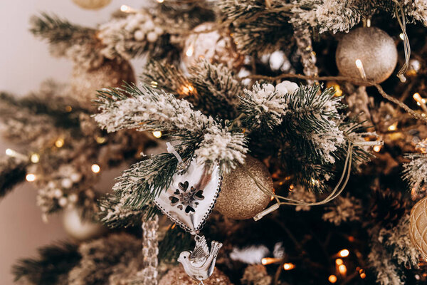 The Christmas tree is beautifully decorated with gold ornaments and silver accents creating a warm holiday atmosphere in the living room.