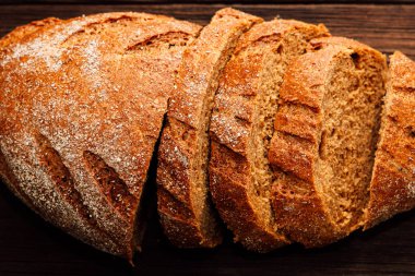 Taze pişmiş kahverengi ekmek mükemmel bir şekilde dilimlenir. Kahvaltıda kabuklu dış ve yumuşak içini gösterir..