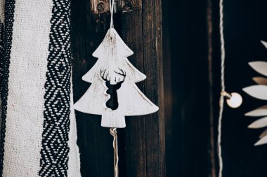 Noel ağacını andıran yaratıcı bir süs geyik tasarımı taşralı ahşap bir arka planda asılı mevsimsel dekoru yükselten.