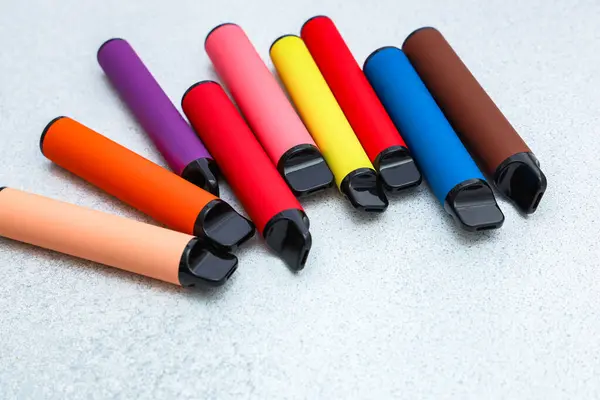 Farklı renklerde çeşitli keçeli kalemler pürüzsüz gri bir yüzey üzerinde düzgün bir şekilde düzenlenir parlak tasarımlar ve canlı renkler sergilenir..