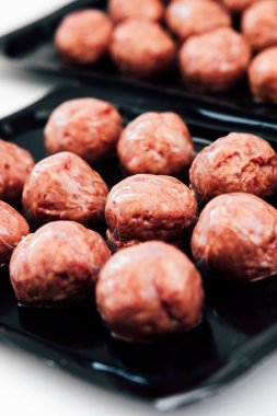 Çiğ köfteler siyah tepsilerde servis edilecek. Taze malzemeler ve sunuma dikkat..