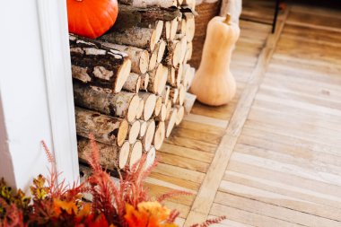 Yakacak odun yığını ve turuncu balkabağı sıcak bir sonbahar atmosferi yaratır..