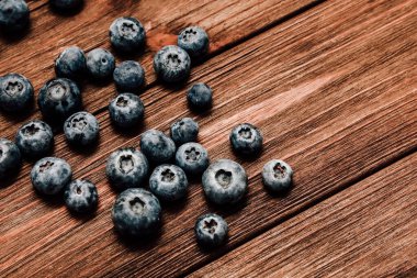 Sulu yaban mersinleri, yumuşak doğal ışık altında canlı renklerini ve dokularını vurgulayan eskimiş ahşap bir yüzeye yayılır..