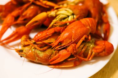 Parlak renkli kerevit, beyaz bir tabağa yerleştirilmiş. Misafirleri, dost canlısı bir buluşmada lezzetli bir yaz yemeğinin tadını çıkarmaya davet ediyor..