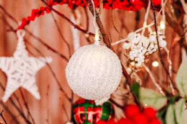 Parlak ve pırıl pırıl süsler kırmızı aksanlar ve parıldayan ışıklarla süslenmiş güzel dekore edilmiş bir ağaca asılır. Tatil sezonu için ortam sıcak ve şenlikli..